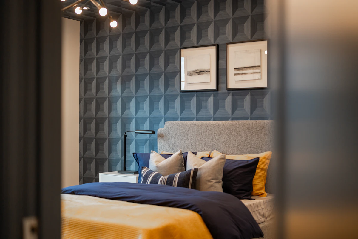 Modern bedroom with a textured blue accent wall and framed artwork