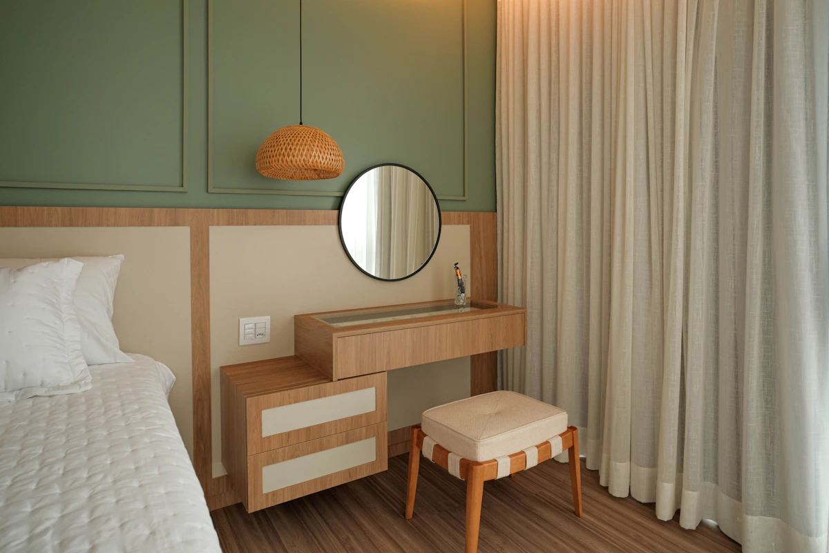 Modern bedroom with a compact built in vanity, mirror, drawers, and chair
