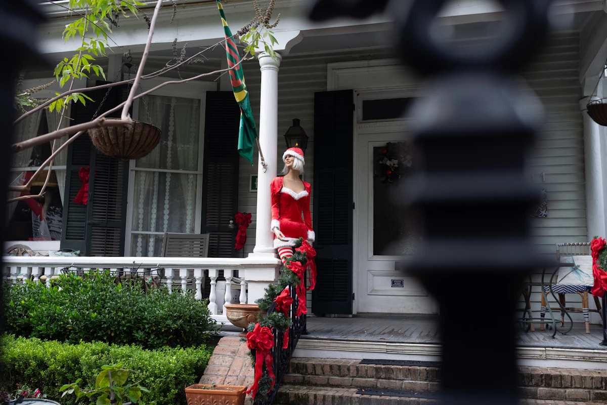 Front porch decorated with Christmas greenery and garland around the entry
