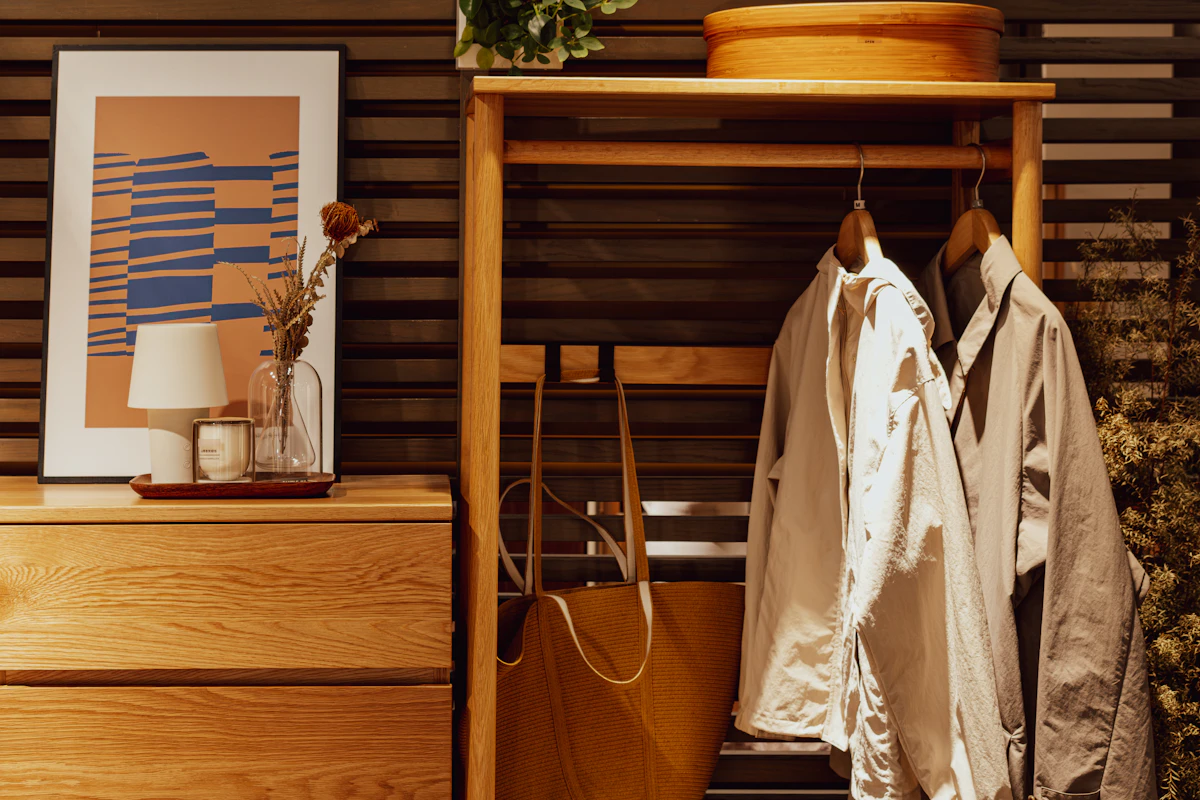 Compact apartment entryway with shallow storage, hanging coats and framed wall art