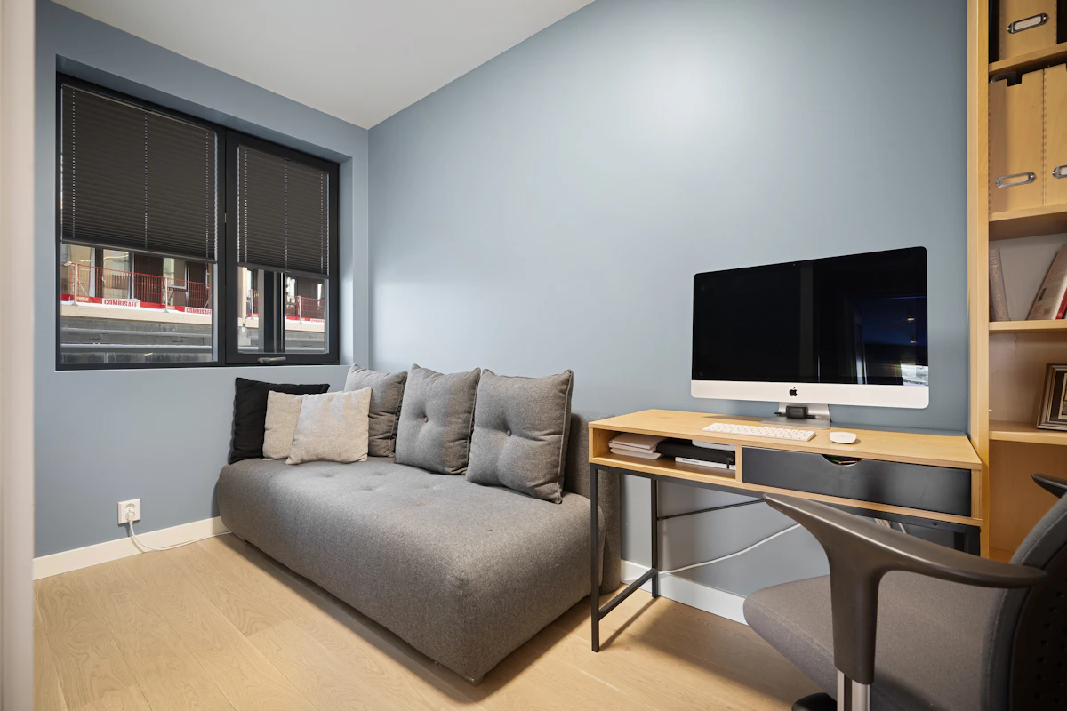 Small apartment living room with a compact desk positioned behind the sofa