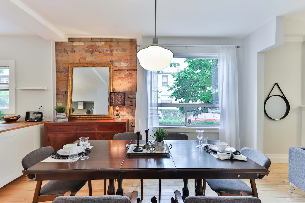 Dining room with a dark painted accent wall behind a wooden table and chairs
