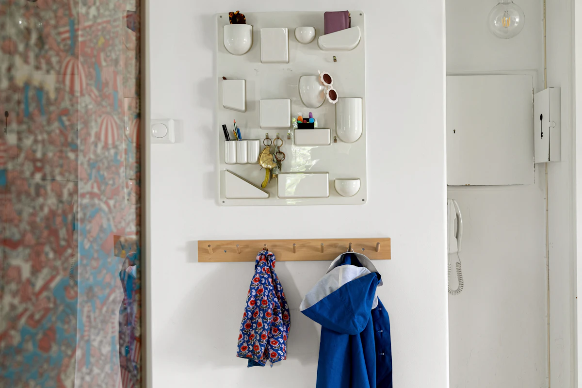 Compact entryway wall hooks holding a coat and bag without using floor space