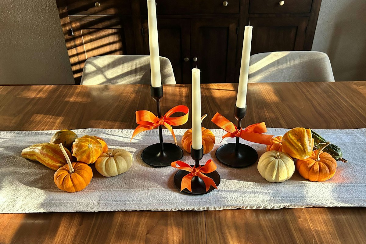 Halloween party table decor with pumpkins, gourds and candlesticks