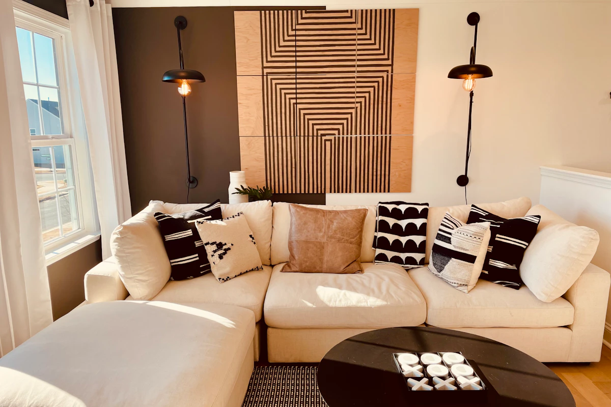 Modern living room with a subtle accent wall behind a white sofa and black coffee table