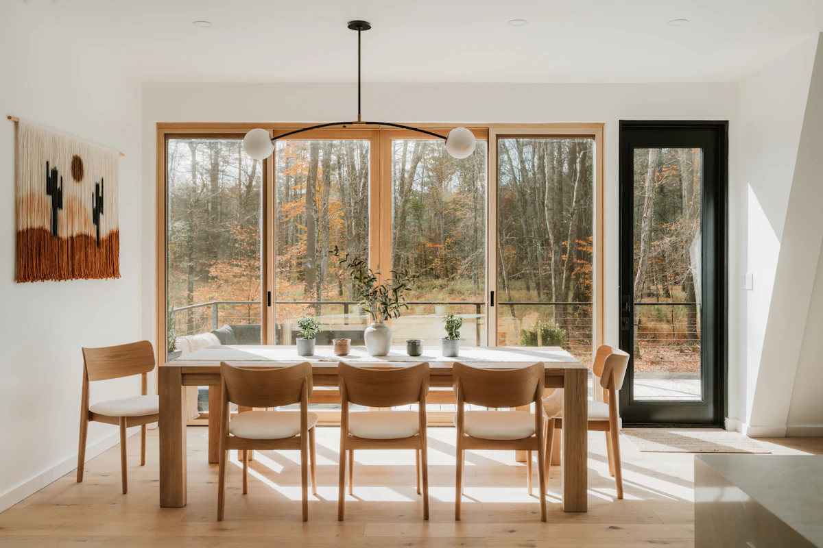Warm dining room with natural wood table, layered textiles, and understated autumn styling