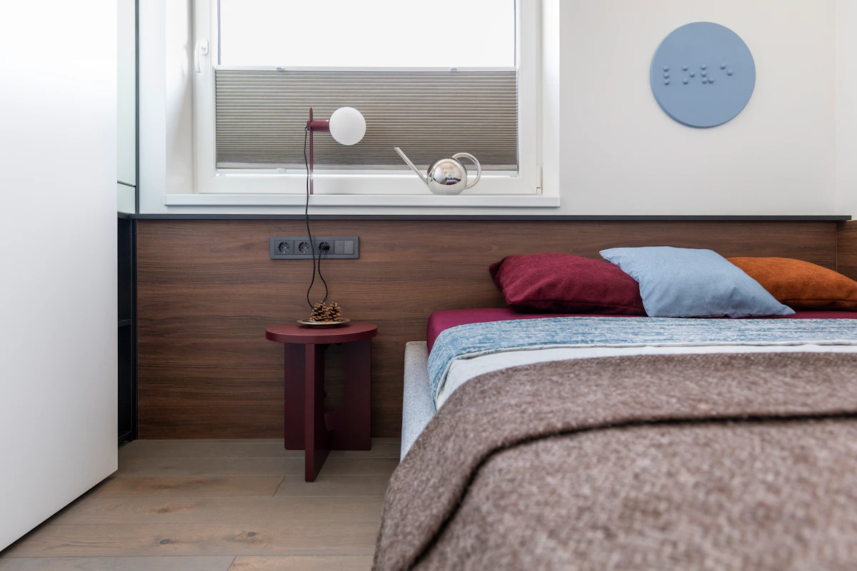 Apartment bedroom with warm bedside lighting and compact wall-side lamps