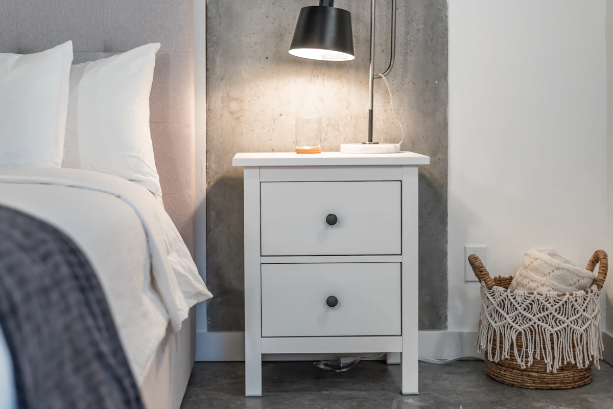 Warm small bedroom with compact storage furniture and a clear walking path around the bed