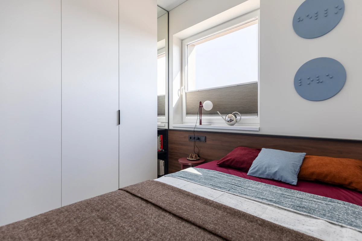 Small bedroom with a storage bed and compact furniture in a warm modern apartment