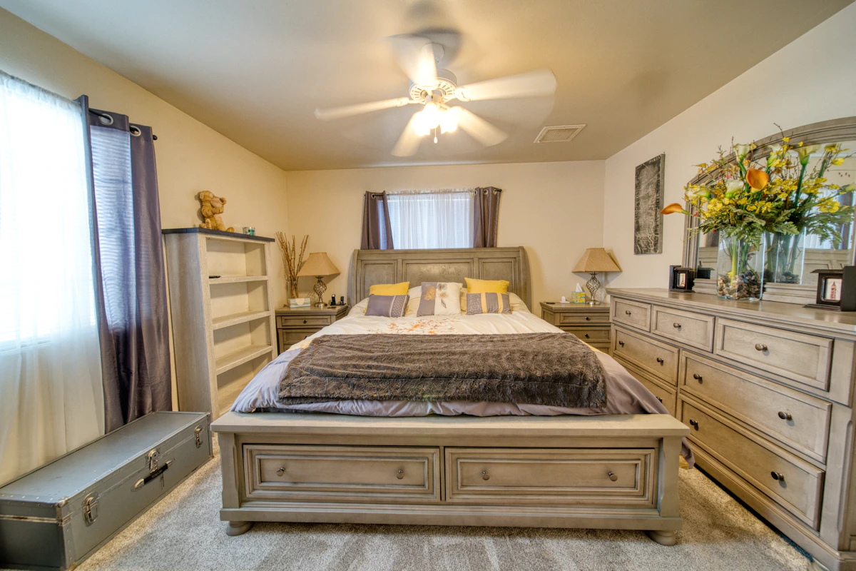 Small bedroom with bed and nearby drawer storage showing how low space can support organized clothing storage