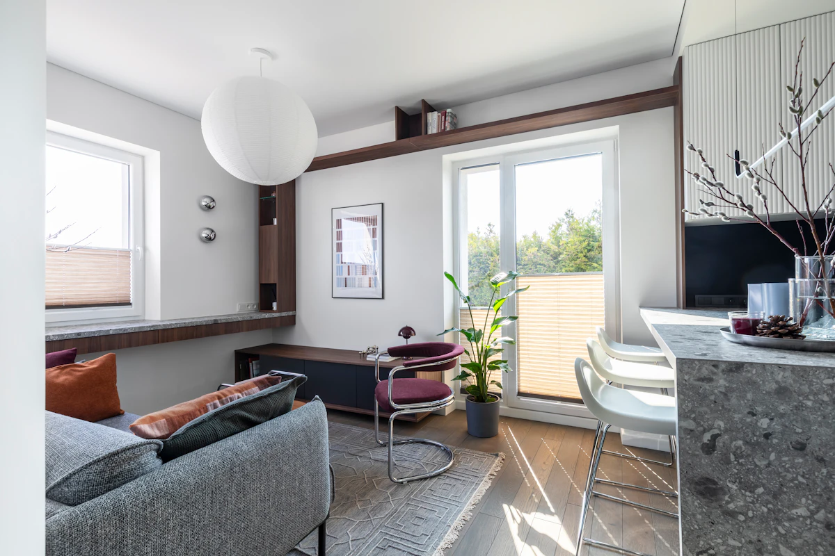 Wall bed integrated into a compact apartment with warm wood cabinetry and layered lighting