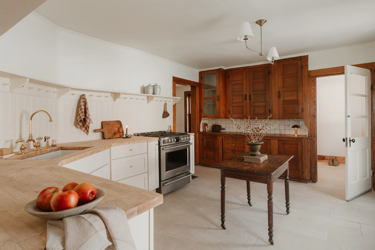 Warm farmhouse kitchen with white cabinets, wood accents and a classic tiled backsplash