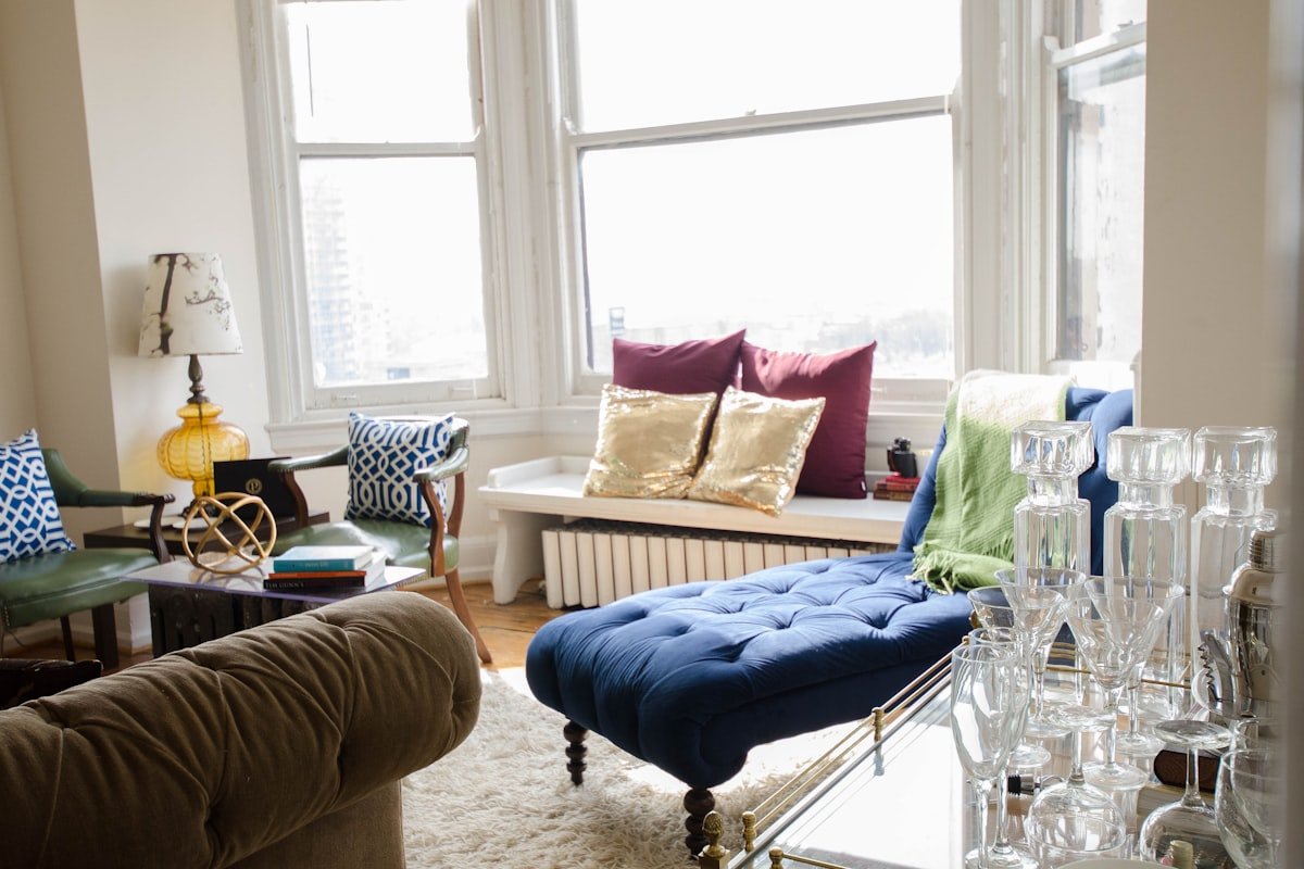 Apartment living room with a large wall mirror and sofa reflecting natural light