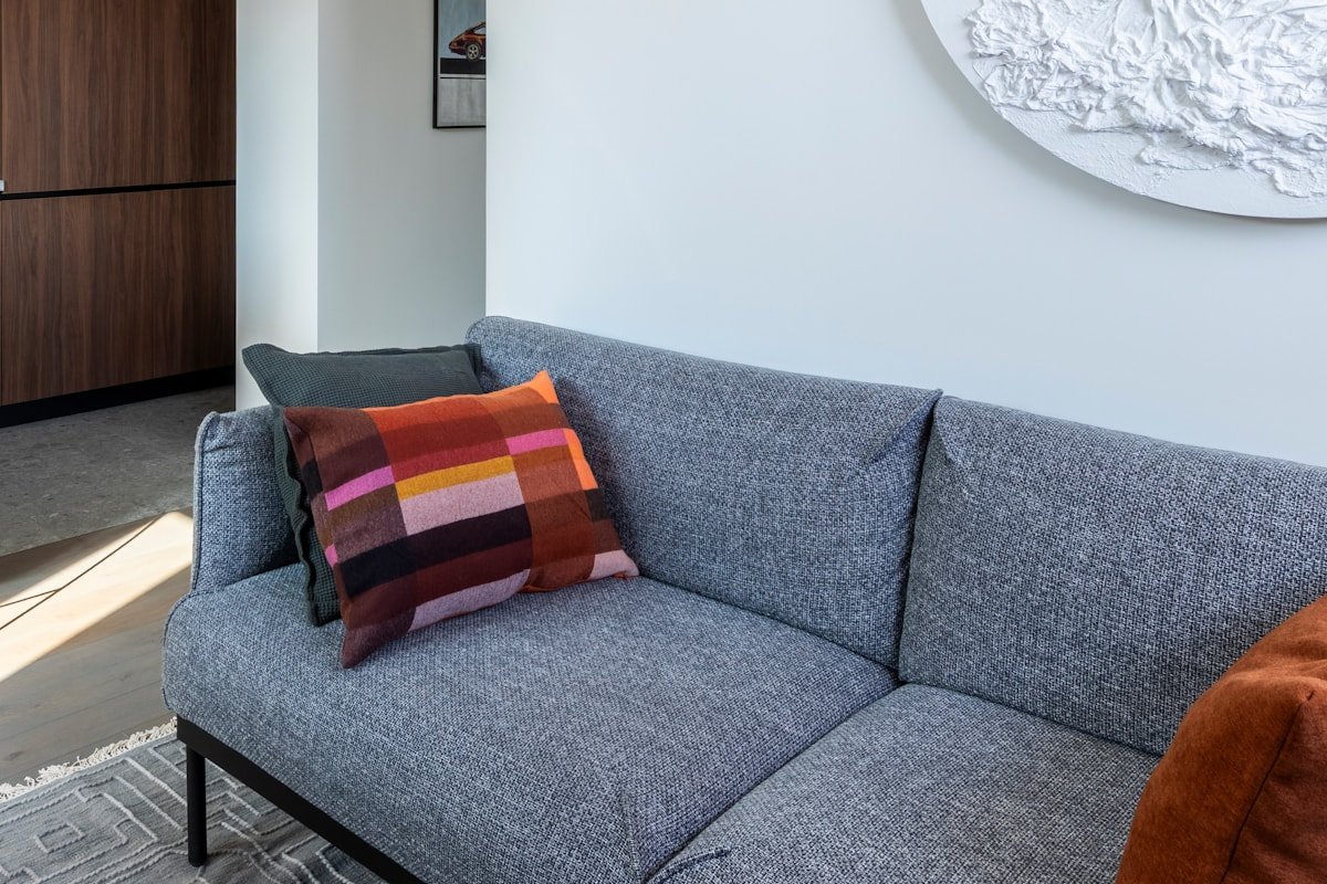 Apartment living room with layered lighting, artwork and soft furnishings