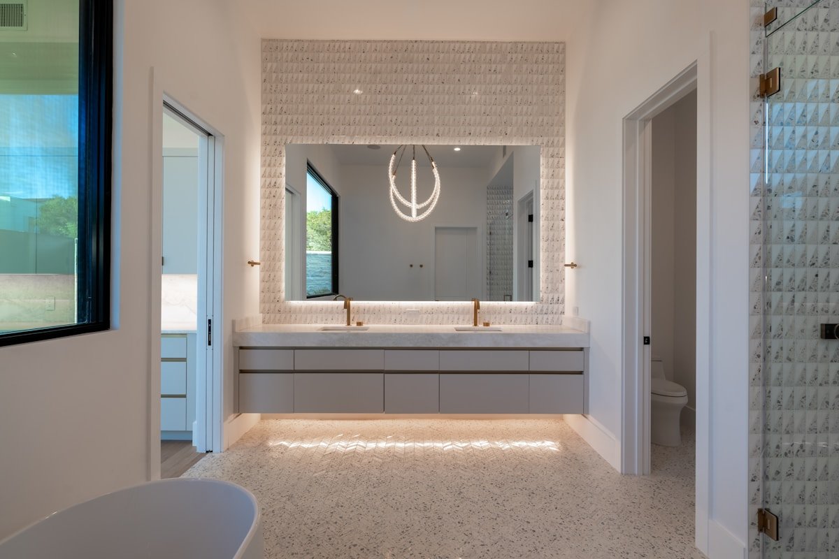 Bathroom with an illuminated mirror and layered vanity lighting