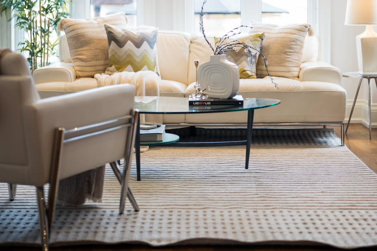 Bright living room with sofa and chairs arranged around a large area rug