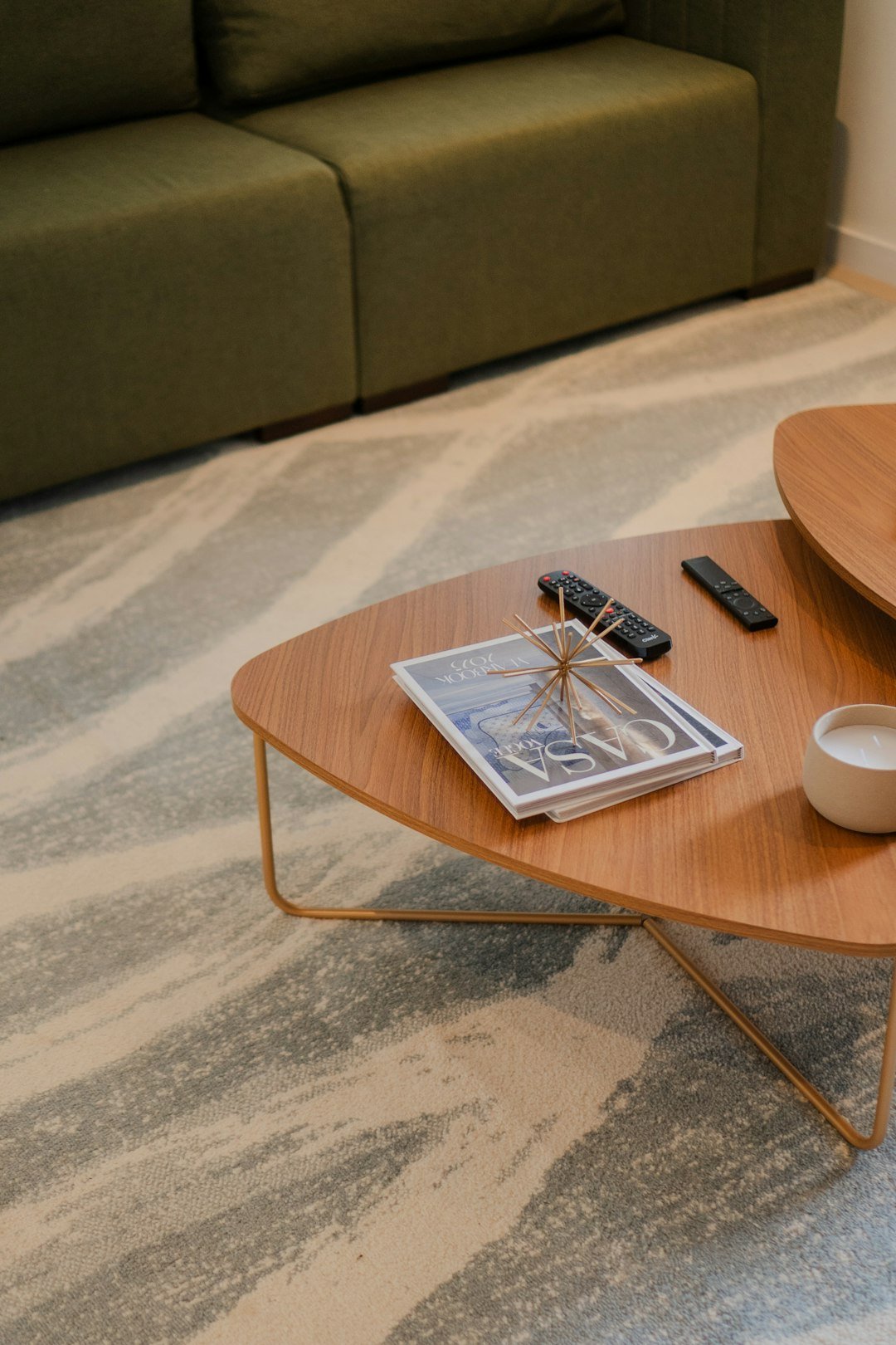 Coffee table with magazine, remotes, and candle arranged with clear open space for daily use