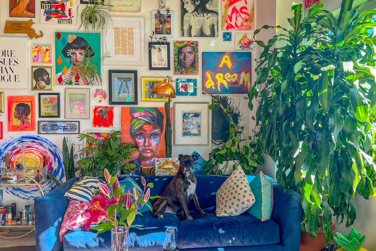Colorful maximalist gallery wall with mixed framed art above a blue sofa