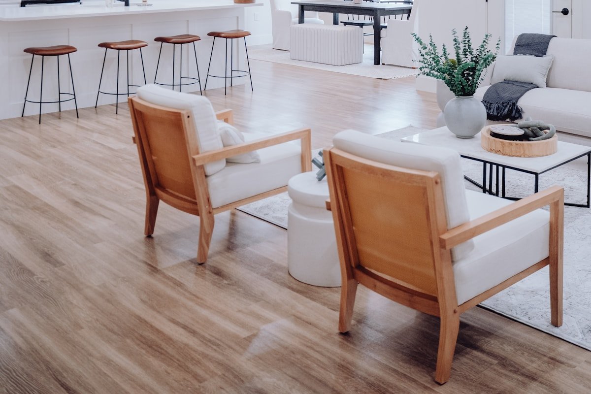 Connected living room and kitchen with repeated neutral colors and wood tones