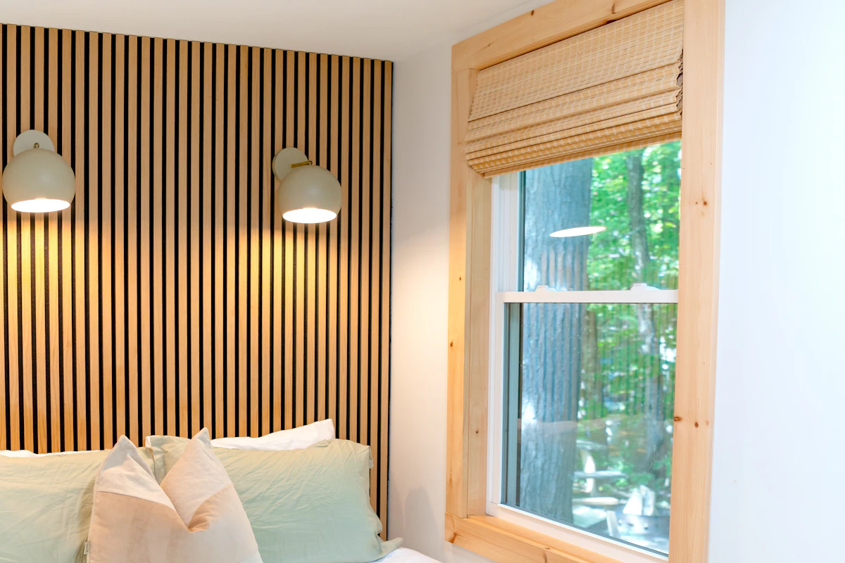 Cozy bedroom with sage green bedding and natural wood wall