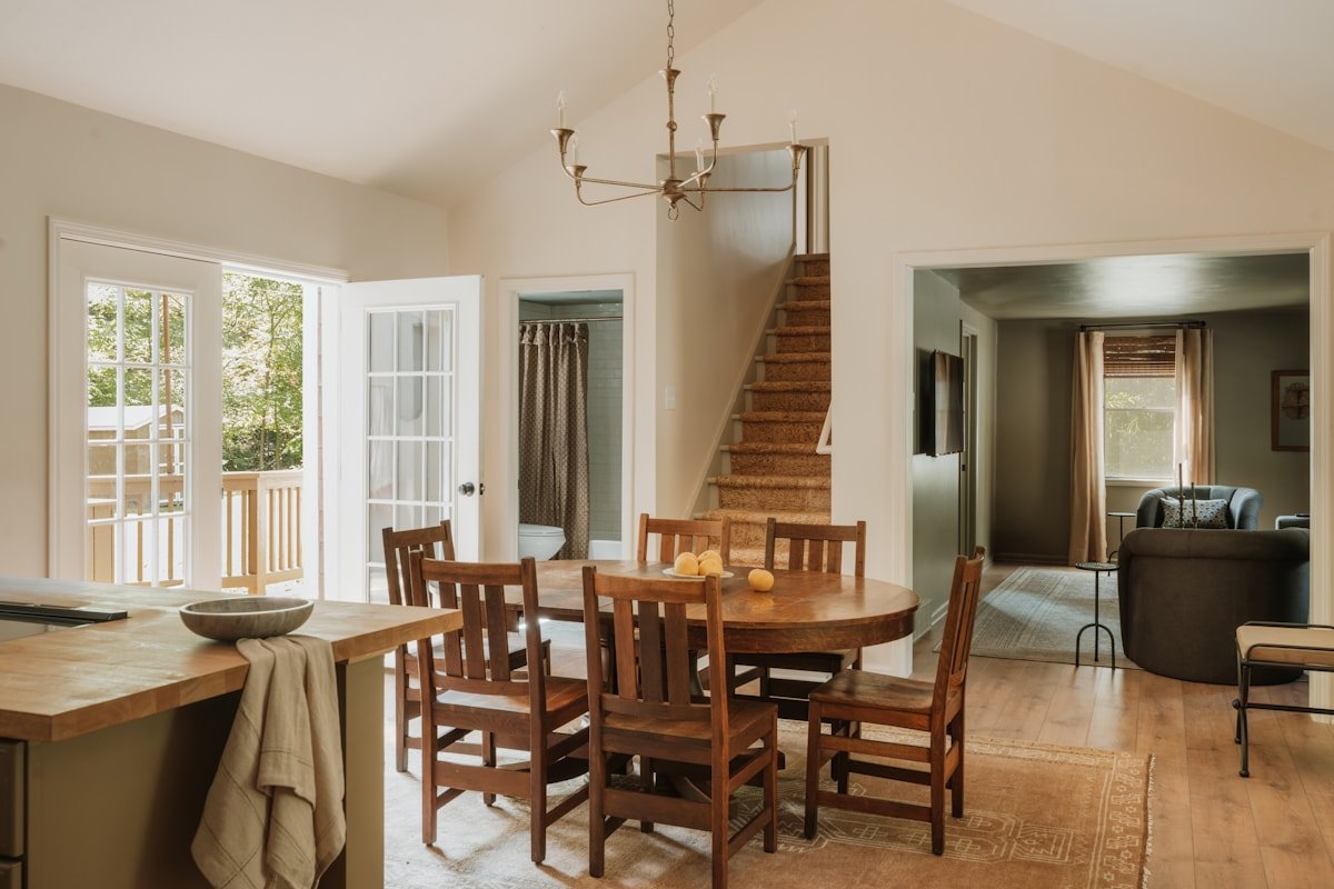 Dining area with warm wood and neutral finishes connecting adjacent spaces