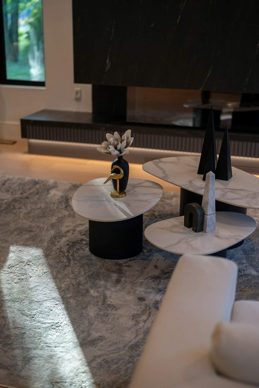 Layered modern living room with tiered coffee tables and minimal decorative objects