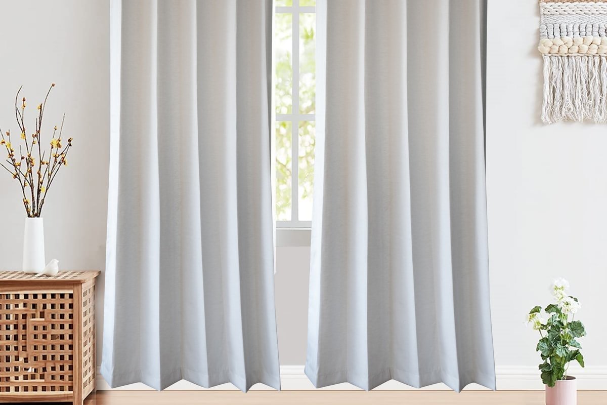 Light gray curtains hanging from a simple rod in a rental-friendly window setup