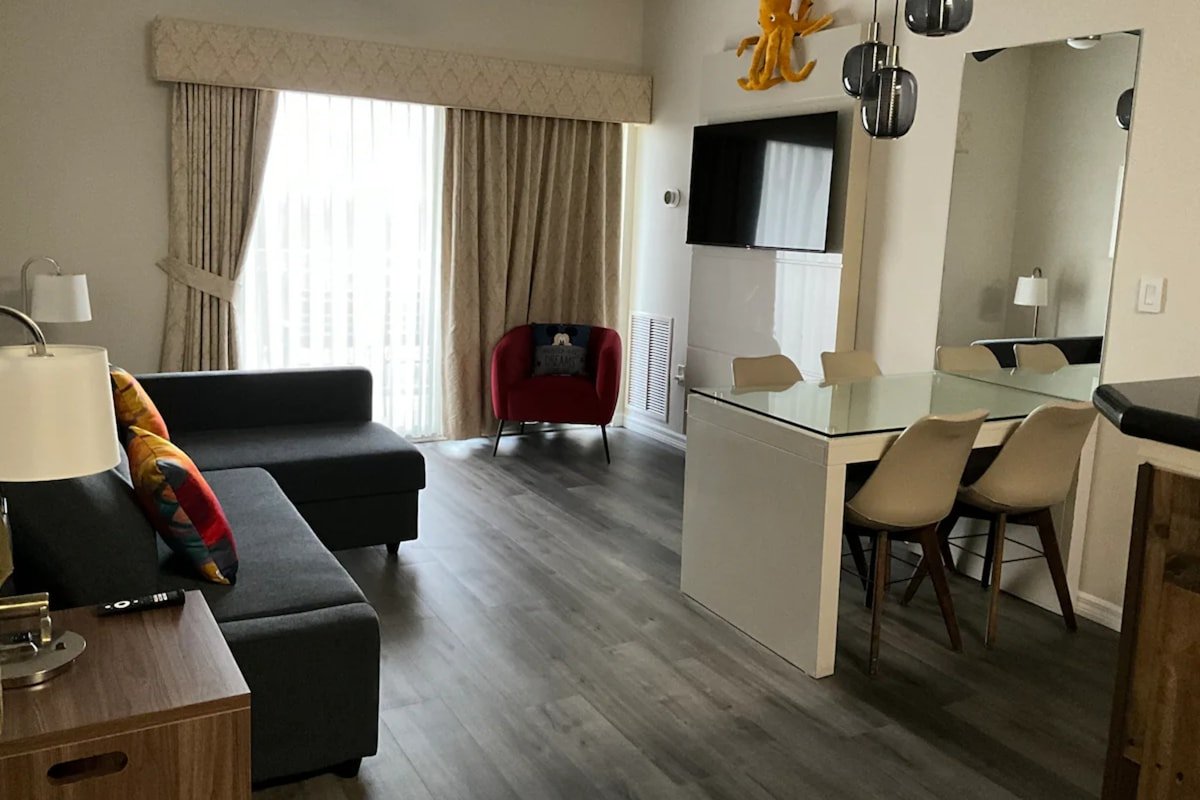 Living and dining room with full-height curtains in a renter-friendly apartment