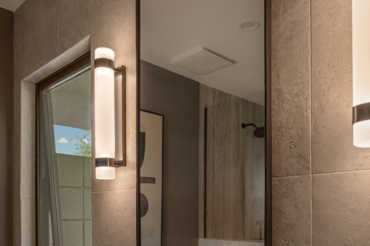 Modern bathroom sink with a large mirror and balanced vanity lighting