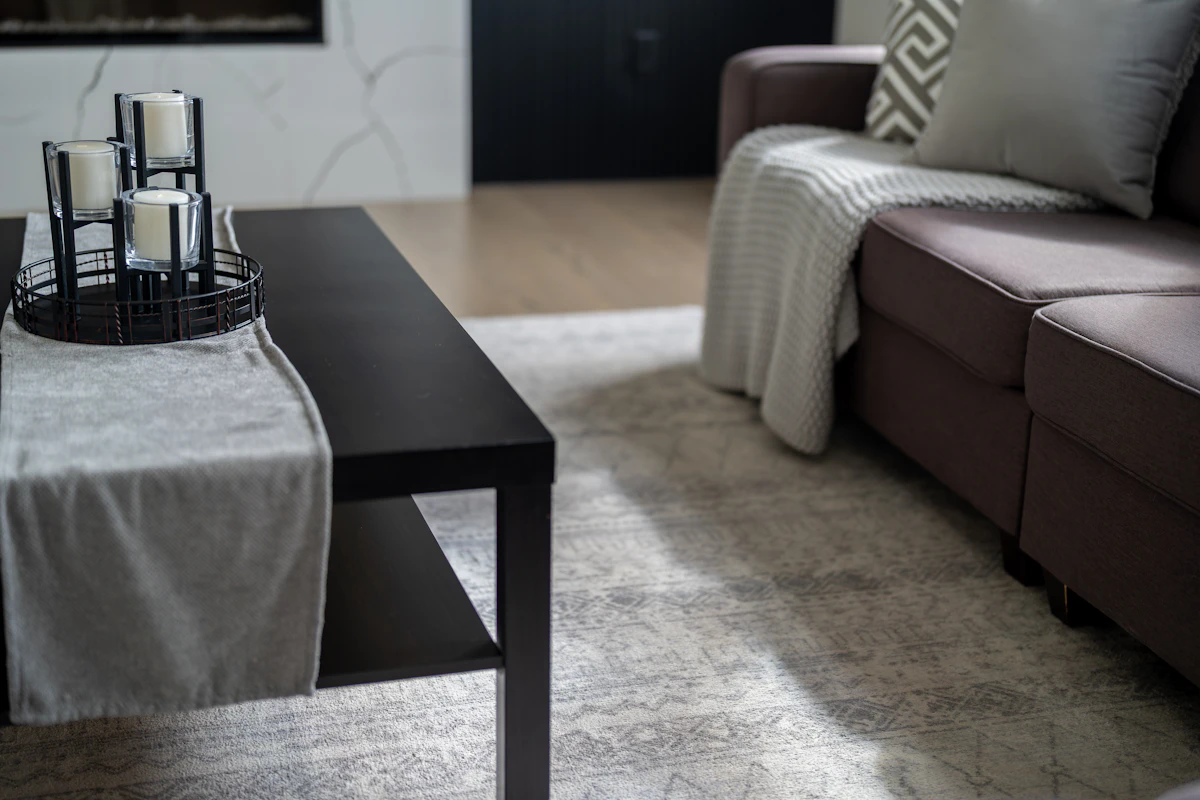 Modern living room with sofa, coffee table, and rug sized to connect the seating area