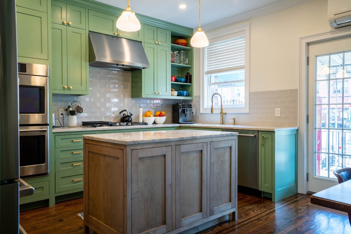 Small kitchen with green cabinets and a bright open center island