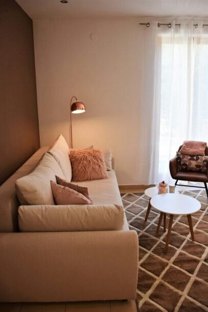 Small warm modern living room with a sofa, coffee table, and natural light